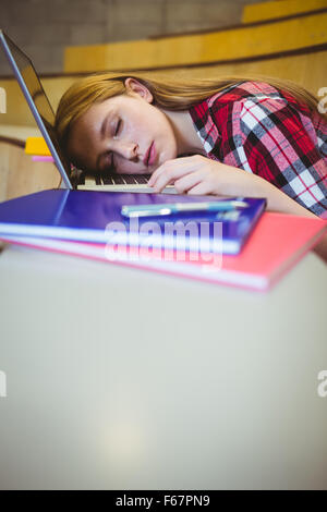 Bionda studente dormire sul computer portatile Foto Stock