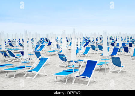 Ombrelloni da spiaggia chiusa e sdraio blu Foto Stock