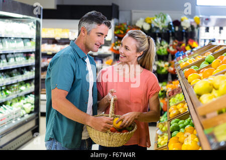 Coppia felice mettendo apple nel cestello Foto Stock