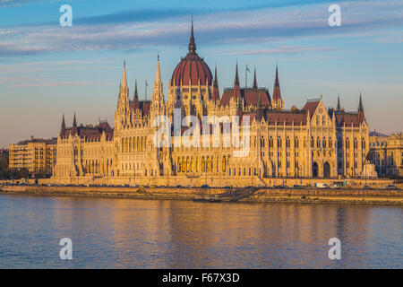 The outside of the Hungarian Parliament Building from the side towards sunset. Reflections can be seen in the water. Foto Stock
