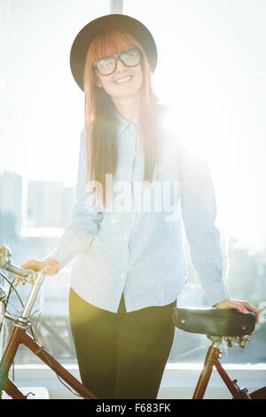 Tanga sorridente donna appoggiato su di una bicicletta Foto Stock
