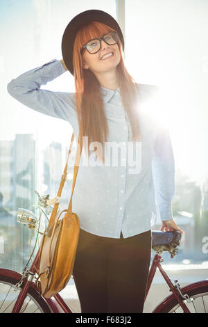 Tanga sorridente donna appoggiato su di una bicicletta Foto Stock