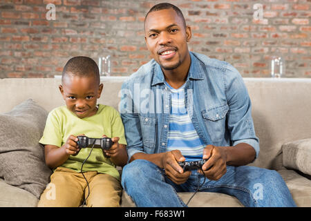 Padre e figlio di giocare con i videogiochi insieme Foto Stock