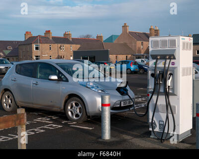 Ricarica di un'auto elettrica con un caricabatteria pubblico Foto Stock