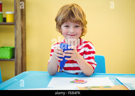 Piccolo boy utilizzando una bottiglia di colla Foto Stock