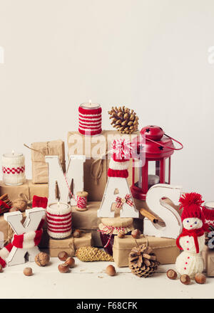 Stile vintage. Scheda di Natale. Decorazioni di Natale - lettere XMAS, doni, maglieria, candele, noci, spezie. Foto Stock