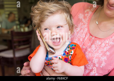 Un anno di età baby parlando su un Apple iPhone Foto Stock