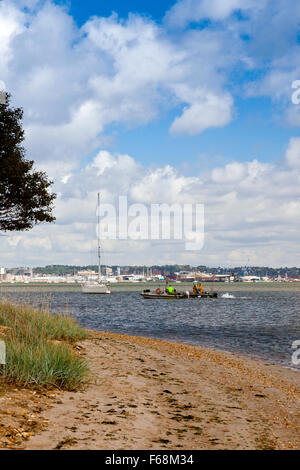 Due barche da pesca sul loro modo home passato la RSPB Arne riserva nel porto di Poole, Dorset, Inghilterra. Foto Stock