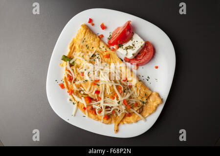 Ristorante e bar Colazione La colazione è servita su una piastra bianca, uova, formaggio, pomodori Foto Stock