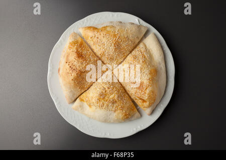 Pane pizza con sussame sulla piastra bianca Foto Stock