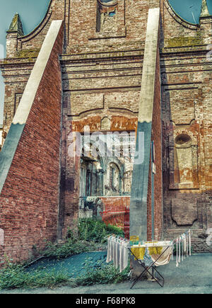 Vestiti appesi ad asciugare su una rastrelliera per essiccamento di fronte tra le rovine storiche in Italia Foto Stock