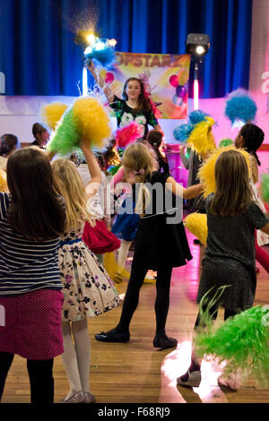 Ritratto verticale di giovani ragazze che ballano con il pom pom ad una festa di compleanno. Foto Stock