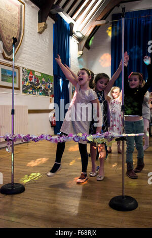 Ritratto verticale delle ragazze giovani che partecipano a un 'limbo' concorrenza a una festa di compleanno. Foto Stock