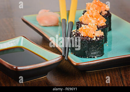 Rotoli di sushi servita sulla piastra blu Foto Stock