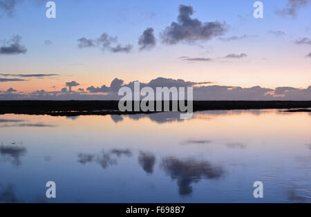 Tramonto con nuvole di luce riflessa in un estuario a pykkvibaer, sud Islanda Foto Stock