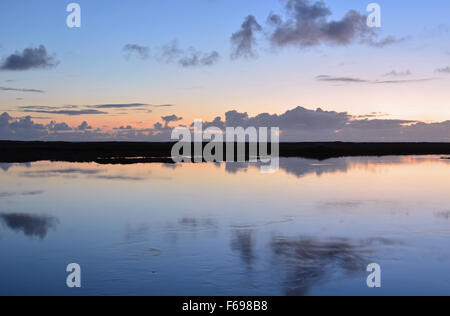 Tramonto con nuvole di luce riflessa in un estuario a pykkvibaer, sud Islanda Foto Stock