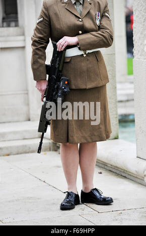 Femmina soldato dell'esercito nelle forze armate britanniche che trasportano una pistola arma Foto Stock