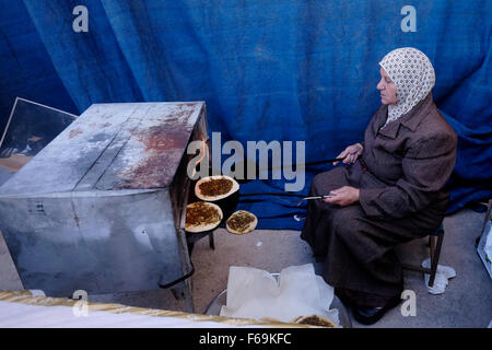 Una donna araba israeliana cuoce il tradizionale pane Pita spalmato con olio d'oliva e Zaatar nella città araba mista ebraica di Maalot-Tarshiha nel nord della Galilea in Israele Foto Stock