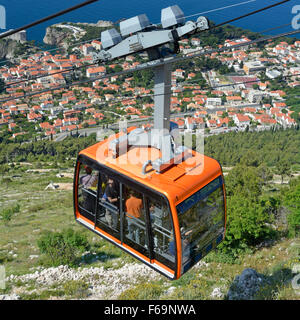 Dubrovnik Croazia Funivia caricato con i passeggeri vicino alla parte superiore della collina SRD con vista alla vecchia città murata & blu del Mare Adriatico al di sotto di Foto Stock