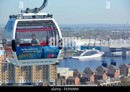 Emirates funivia passeggeri in funivia attraversando parte della London Docklands Londra est con hotel galleggiante ormeggiato a Excel Exhibition Centre Regno Unito Foto Stock