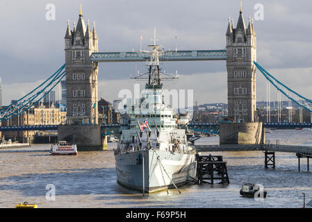 HMS Belfast ancorata sul Tamigi di fronte a Londra il famoso Tower Bridge nel tardo autunno del sole a marea alta. Foto Stock