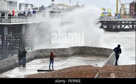 Brighton, Regno Unito. Xv Nov, 2015. Le persone cercano di ottenere uno sguardo più da vicino come onde giganti crash sul lungomare di Brighton come gale force vento e pioggia pastella costa sud. I resti di uragano Kate sono previsioni per interessare zone della Gran Bretagna in tutto i prossimi giorni. Credito: Simon Dack/Alamy Live News Foto Stock