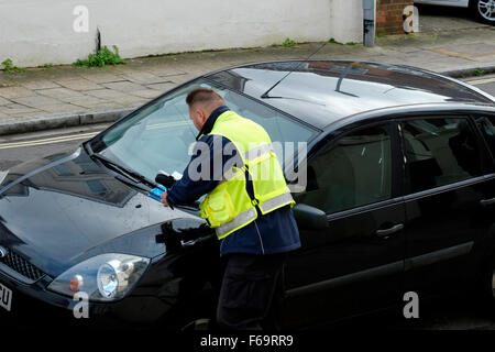 Vigile di emettere un biglietto di parcheggio per una violazione England Regno Unito Foto Stock