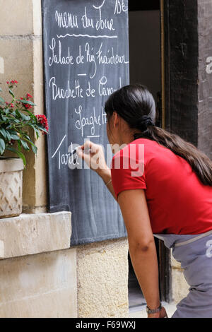 Donna menu scrittura sul ristorante lavagna, Chinon, Indre et Loire, Francia, Europa Foto Stock