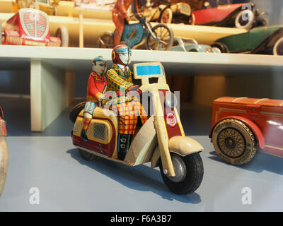 Un giocattolo vintage a forma di orologio raffigurante un vecchio scooter, in mostra al Deventer Toy Museum, che mostra l'artigianato dei giocattoli del XX secolo e il design nostalgico. Foto Stock