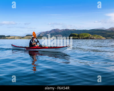 Donna in pensione il kayak da mare intorno all'Isola Shuna sul Loch Linnhe, Scozia occidentale Foto Stock