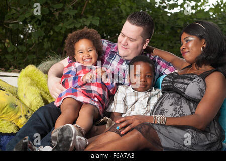 Famiglia africana è seduta sul divano nel giardino Foto Stock