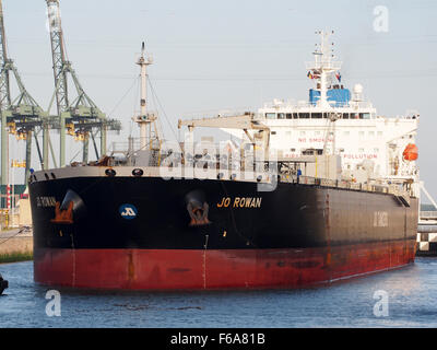 Questa immagine mostra la Jo Rowan (IMO 9602710), una nave ancorata al Berendrechtsluis nel porto di Anversa. Si tratta di una grande nave portacontainer, equipaggiata anche per il trasporto di petrolio, gas e merci generiche. La scena include gru, strutture di stoccaggio e varie merci caricate e scaricate, riflettendo le operazioni logistiche e di trasporto in uno dei porti più trafficati d'Europa. Foto Stock