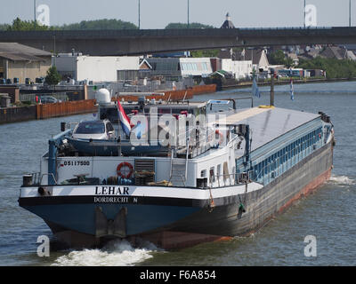 Questa immagine mostra una nave portacontainer ancorata al canale Amsterdam-Rijn, con una gru e un trasporto di merci generiche, tra cui una petroliera e una petroliera. La scena raffigura le attività logistiche nel trafficato nodo dei trasporti del canale. Foto Stock