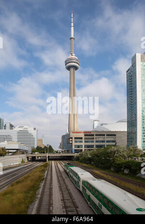 Un treno Go-Transit dirigendosi verso Toronto Union Station e la CN tower in background. Foto Stock