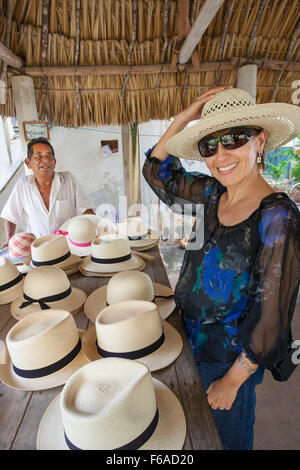 Una donna cerca su un panama o jipijapa hat in un piccolo negozio di Becal, Campeche, Messico. Foto Stock