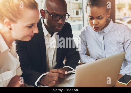 Multi etnico business persone che lavorano in ufficio seduti davanti a un computer portatile, nero business donna, bianco business donna Foto Stock