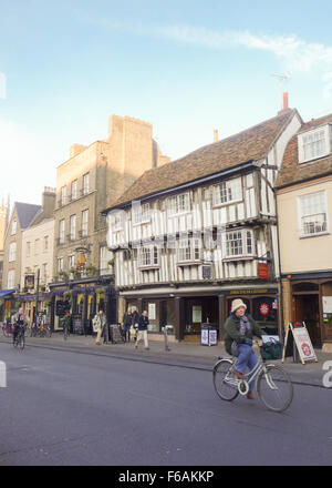 Cambridge Street scene - donna matura escursioni in bicicletta con lo shopping lungo lo storico ponte Street a nord del centro di Cambridge, Regno Unito Foto Stock