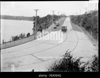 Una veduta della strada principale che conduce da Northcote Wharf, Auckland. Northcote Wharf è una posizione importante ad Auckland, nota per la sua vicinanza al porto e la sua vivace attività sul lungomare. Foto Stock