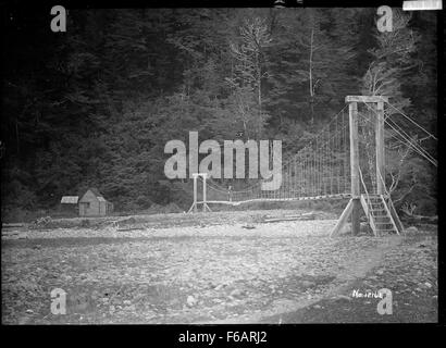 Swing ponte che attraversa il fiume Maruia con bathhouses a Maruia Foto Stock