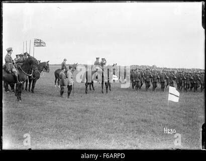 Questa fotografia storica cattura il comandante in capo che esamina le truppe militari neozelandesi mentre marciano davanti a un'esibizione militare formale. L'evento riflette il protocollo militare e la tradizione cerimoniale, evidenziando la disciplina e l'organizzazione delle forze neozelandesi. Foto Stock
