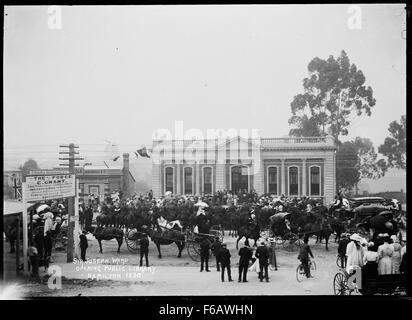 Questa fotografia mostra una grande folla riunita fuori dalla Hamilton Public Library, che riflette un evento pubblico o un raduno. L'immagine cattura il design architettonico dell'edificio, con un'attenzione particolare alla sua grande struttura e alle persone che vi si impegnano. Questa scena evidenzia il significato delle biblioteche pubbliche come hub della comunità. Foto Stock