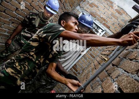 Malese esercito Cpl. Azlan Rosli, centro, assegnati al 2° Squadrone tecnico reale reggimento, E DEGLI STATI UNITI Army Spc. Chris Dobbins, destra, un idraulico con l'Ingegnere 1020th Company, Louisiana National Guard per lavorare insieme a tubazioni di intarsio nel muro di mattoni durante un edificio scolastico progetto a sostegno del funzionamento sciopero Keris 2015 in Tai Ping, Malaysia, Sett. 9, 2015. Sciopero Keris è un U.S. Pacifico esercito-teatro sponsorizzato la cooperazione in materia di sicurezza di esercizio del programma condotto annualmente con il malese delle Forze Armate. (U.S. Esercito foto di Spc. Michael Sharp/rilasciato) Foto Stock