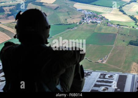 Un U.S. Air Force Loadmaster siede sulla rampa di un C-130 Hercules durante le operazioni di volo a salto internazionale settimana (IJW), Ramstein Air Base, Germania, 8 luglio 2015. Il 435th risposta di emergenza gruppo IJW ospita annualmente, per la creazione di partenariati globali, foster cameratismo fra Stati Uniti e internazionali i paracadutisti e per lo scambio di tattiche di corrente, le tecniche e le procedure relative alle operazioni di volo (linea statica e militari di caduta libera). (U.S. Foto dell'esercito da Staff Sgt. Justin P. Morelli / rilasciato) Foto Stock