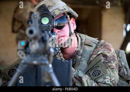 Stati Uniti Pfc dell'esercito. Eric Krussier, un paracadutista assegnato al Bravo truppa, 5° Stormo, 73rd reggimento di cavalleria, 3° Brigata, ottantaduesima Airborne Division, guarda le sue attrattive della sua arma mentre egli tira la sicurezza durante la squadra di formazione a livello di Camp Taji, Iraq, 3 Agosto, 2015. Le forze della coalizione hanno pratica di routine che cosa intendono per insegnare ai soldati iracheni prima di ciascun ciclo di istruzione. Formazione presso l'edificio la capacità del partner sites è parte integrante della Combined Joint Task Force - Funzionamento inerenti risolvere la multinazionale di sforzo per treno iracheno forza di sicurezza personale per sconfiggere lo Stato islamico dell Iraq Foto Stock