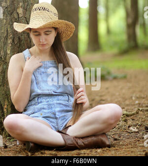Il 16 luglio 2014, Paese meandri ragazza nel vecchio dungaree tagliati corti nei boschi. Foto Stock