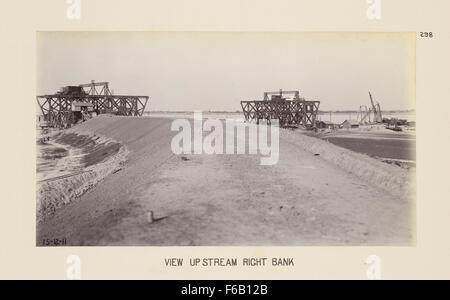 Questa immagine presenta una vista della costruzione del ponte sulla riva destra di un fiume, con l'attenzione sui ponti ferroviari. La scena evidenzia gli sforzi ingegneristici e di costruzione nella costruzione del ponte che facilita il trasporto attraverso il canale. Foto Stock