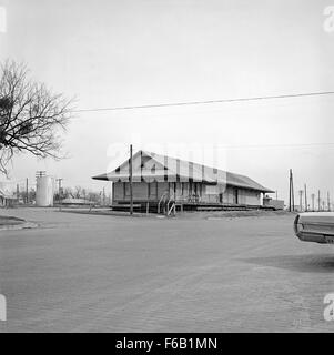 Questa fotografia storica cattura la Southern Pacific Freight Station di Ennis, Texas. Mostra i depositi ferroviari e il significato delle ferrovie nel trasporto del XX secolo, mettendo in evidenza le infrastrutture dell'epoca. Foto Stock