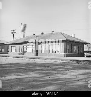 Questa fotografia cattura la Southern Pacific Passenger Station di Ennis, Texas, un importante nodo di trasporto per la Southern Pacific Railroad. L'immagine riflette lo stile architettonico e l'importanza storica della stazione durante l'era dell'espansione ferroviaria negli Stati Uniti Foto Stock