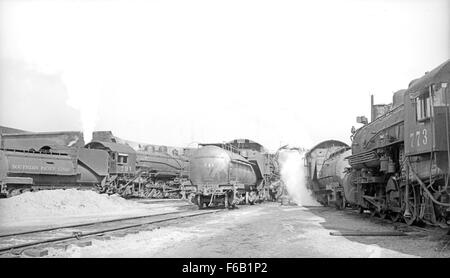 Una fotografia storica della Southern Pacific Roundhouse di Ennis, Texas, con un gruppo di locomotive Espee SP TNO. L'immagine cattura la scala e l'importanza delle infrastrutture ferroviarie all'inizio del XX secolo. Foto Stock