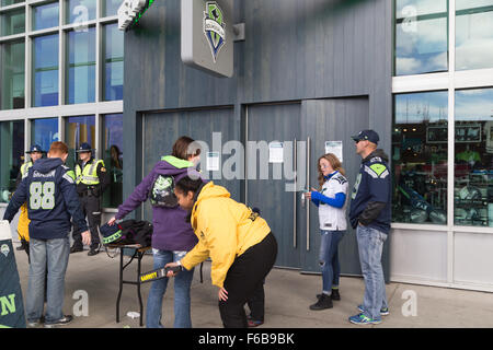 Seattle, Stati Uniti d'America. 15th. Novembre, 2015. Conseguenze del terrorismo a Parigi, Francia, i clienti per il Centurylink stadium sport shop vengono scansionati da stadium il personale addetto alla sicurezza in presenza della Pattuglia sate. Credito: Maria S../Alamy Live News Foto Stock